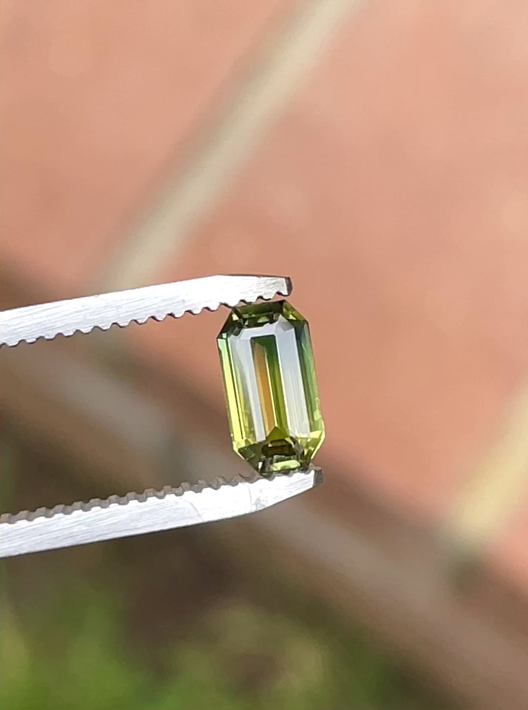 Rotating close-up video of 1.09 carat bi-color sapphire from Diego, Madagascar showing yellow to green hues and octagonal step cut