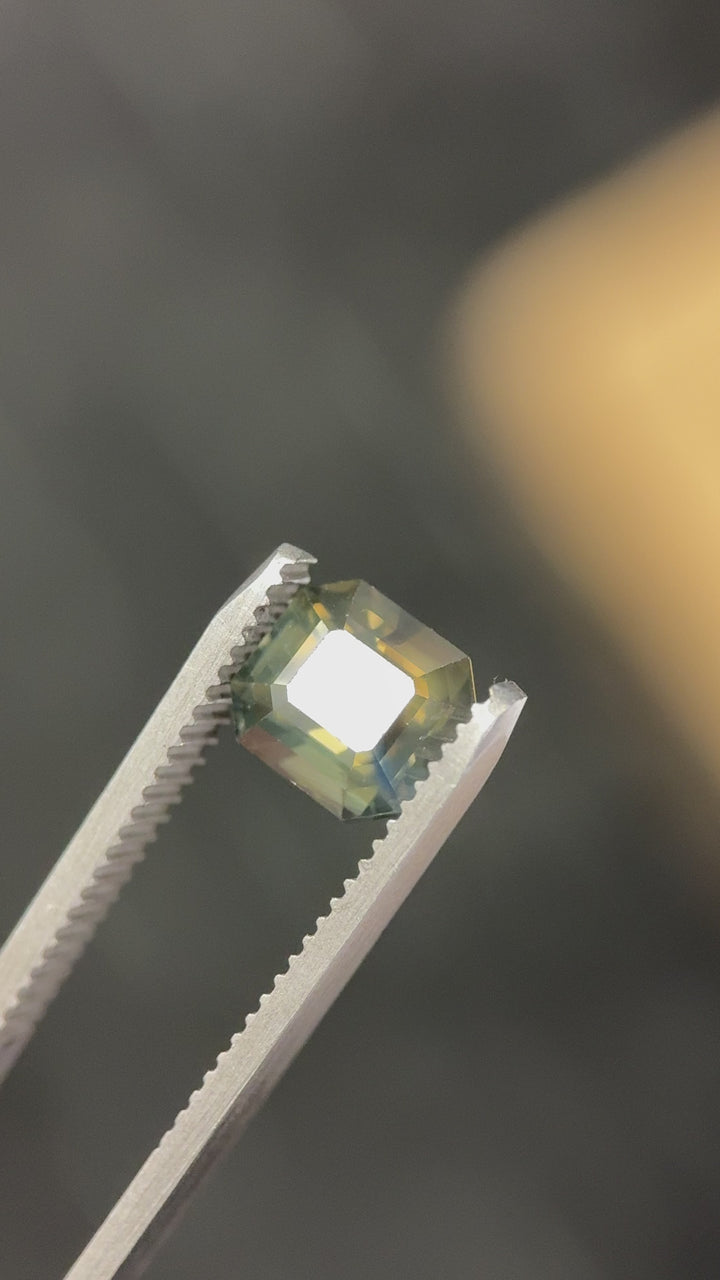 Rotating video of a 3.40CT opalescent emerald cut sapphire from Gombe, Nigeria, highlighting earthy olive teal green color play and natural untreated brilliance