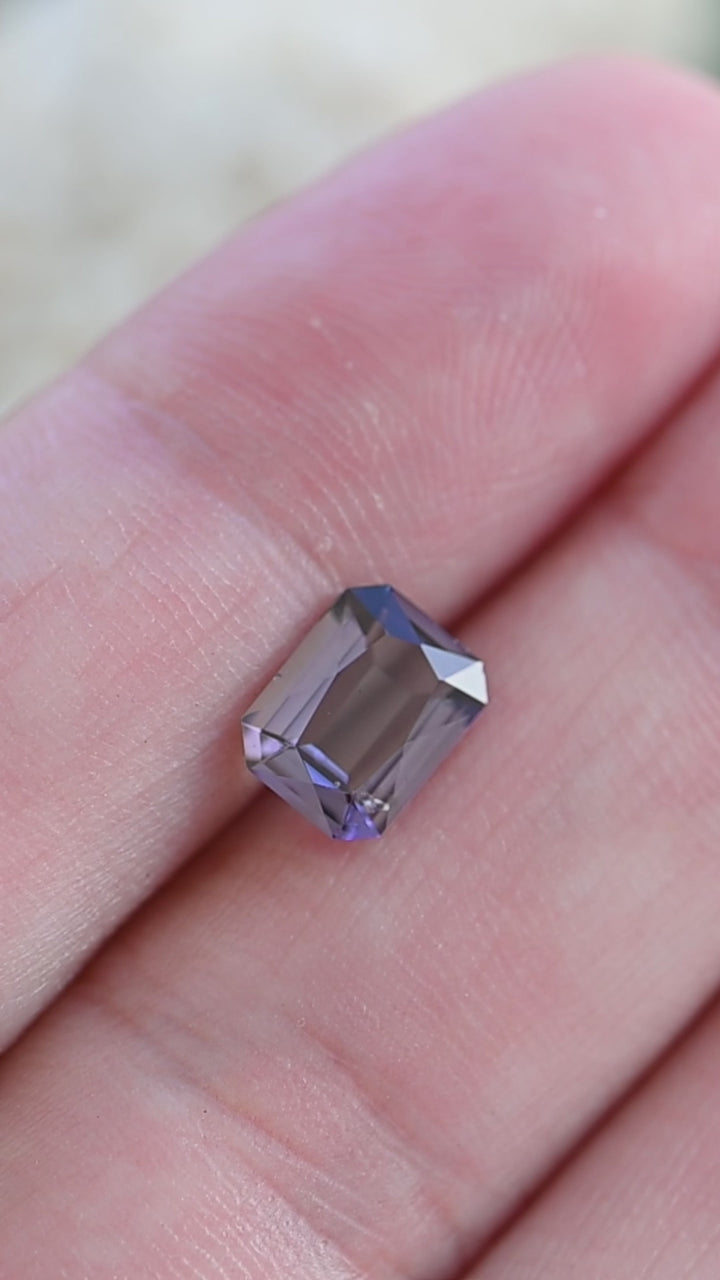 Experience the quiet elegance of this untreated 1.19 carat tanzanite as its custom radiant portrait cut showcases subtle flashes of green, purple, and cool silvery tones.