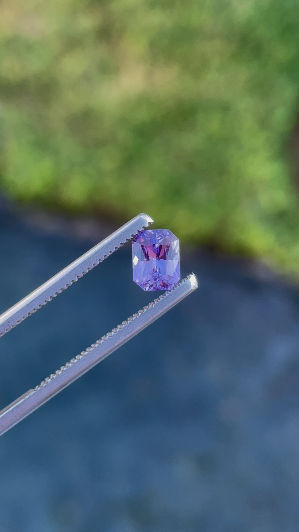 Dynamic video showcasing a 1.05 carat radiant cut sapphire with vivid pink and purple hues, emphasizing its clarity and precise geometric facets, sourced from Sri Lanka.