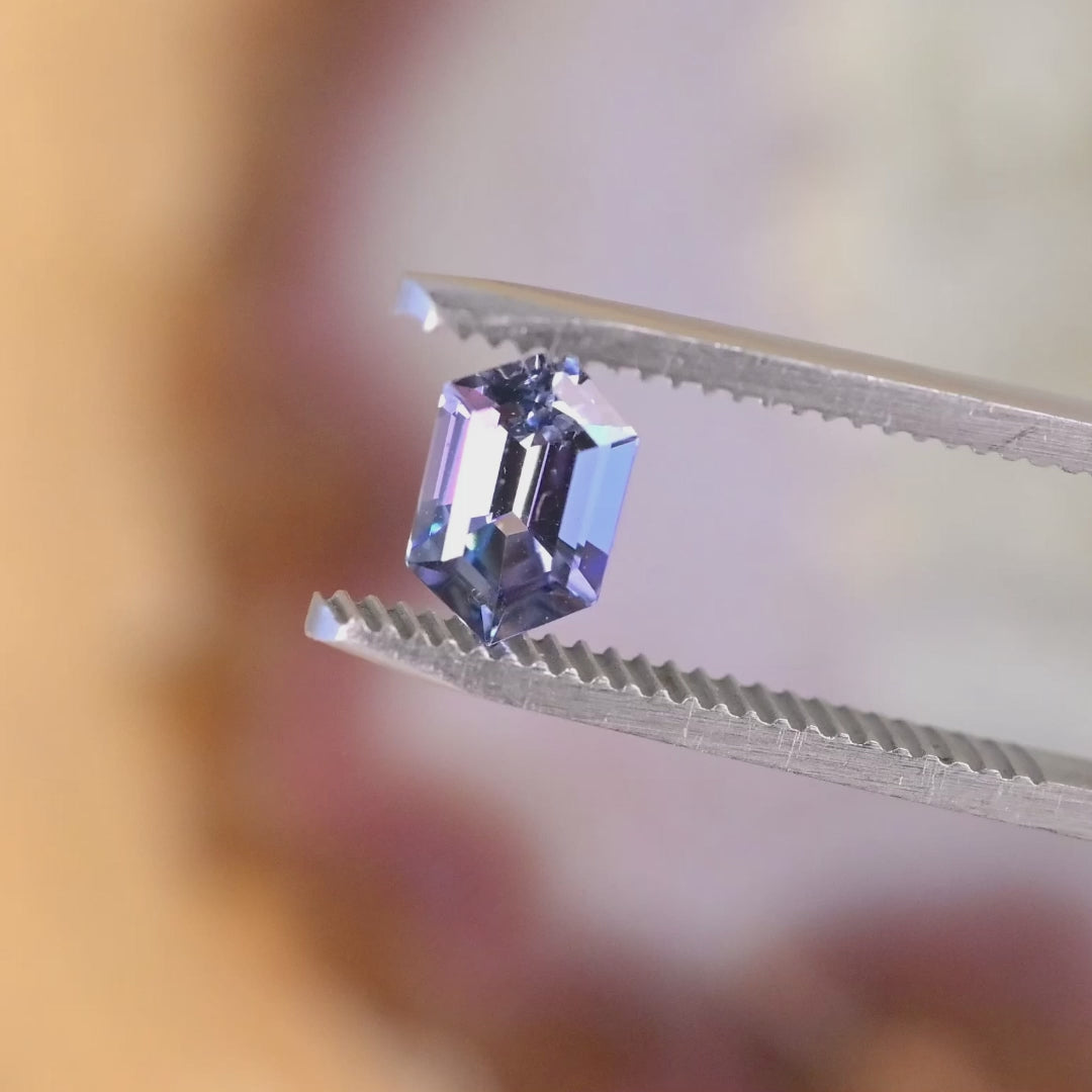 1.24 carat hexagon step cut Tanzanite rotating under light showing teal blue purple color shift precision faceting and brilliance from Merelani Hills