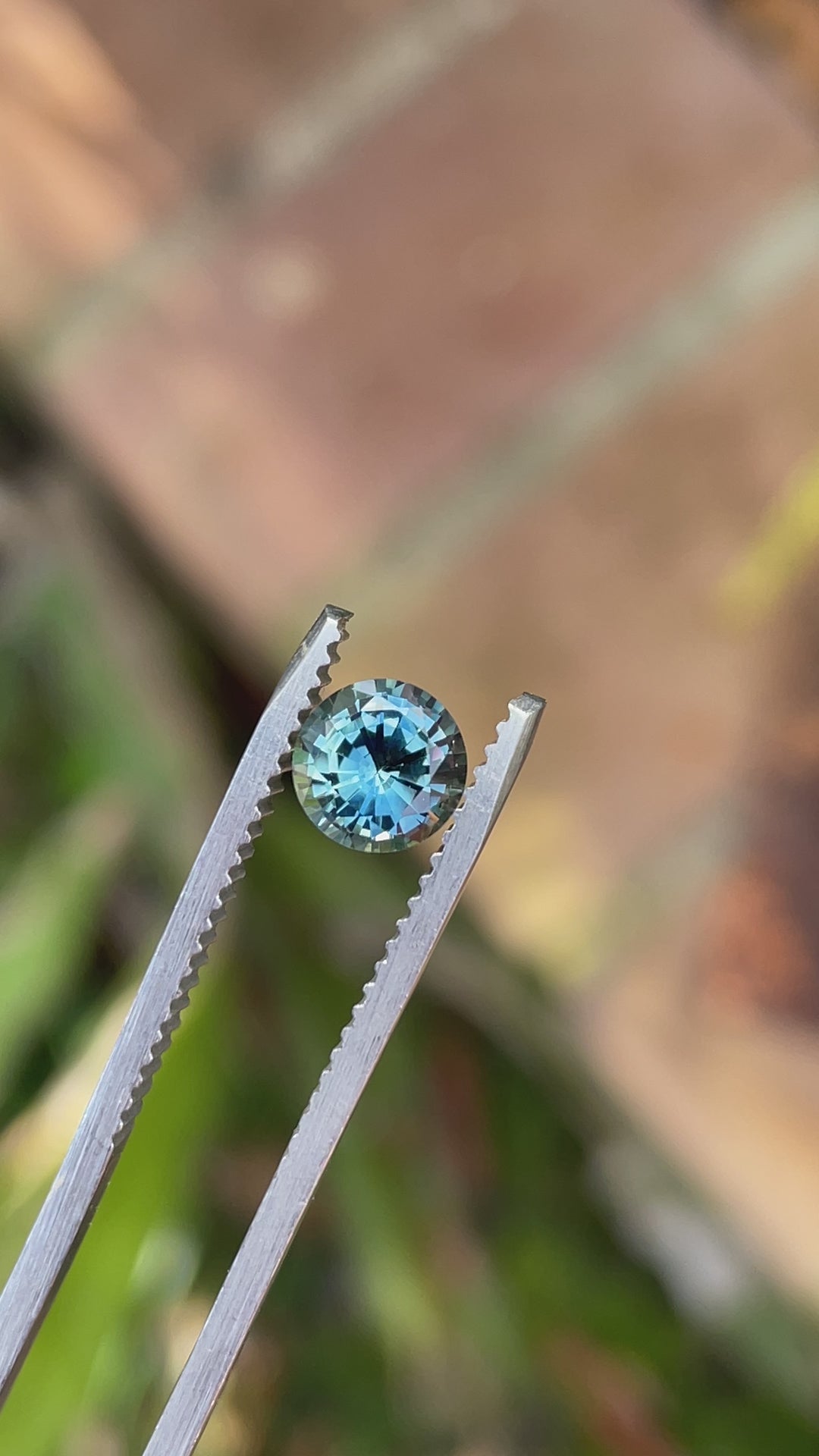 A rotating video of a 1.08-carat round brilliant teal sapphire, showcasing its natural brilliance, color shift, and untreated clarity.