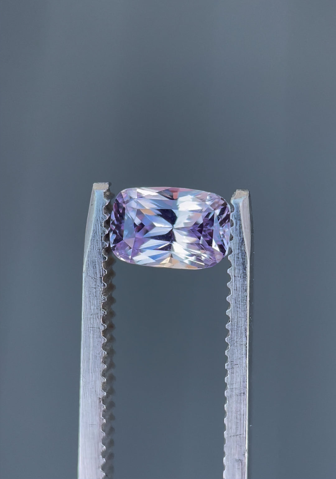 Close-up rotating view of a 1.57-carat pastel pink and purple sapphire with a rectangular cushion brilliant mixed cut, ethically sourced from Sri Lanka.