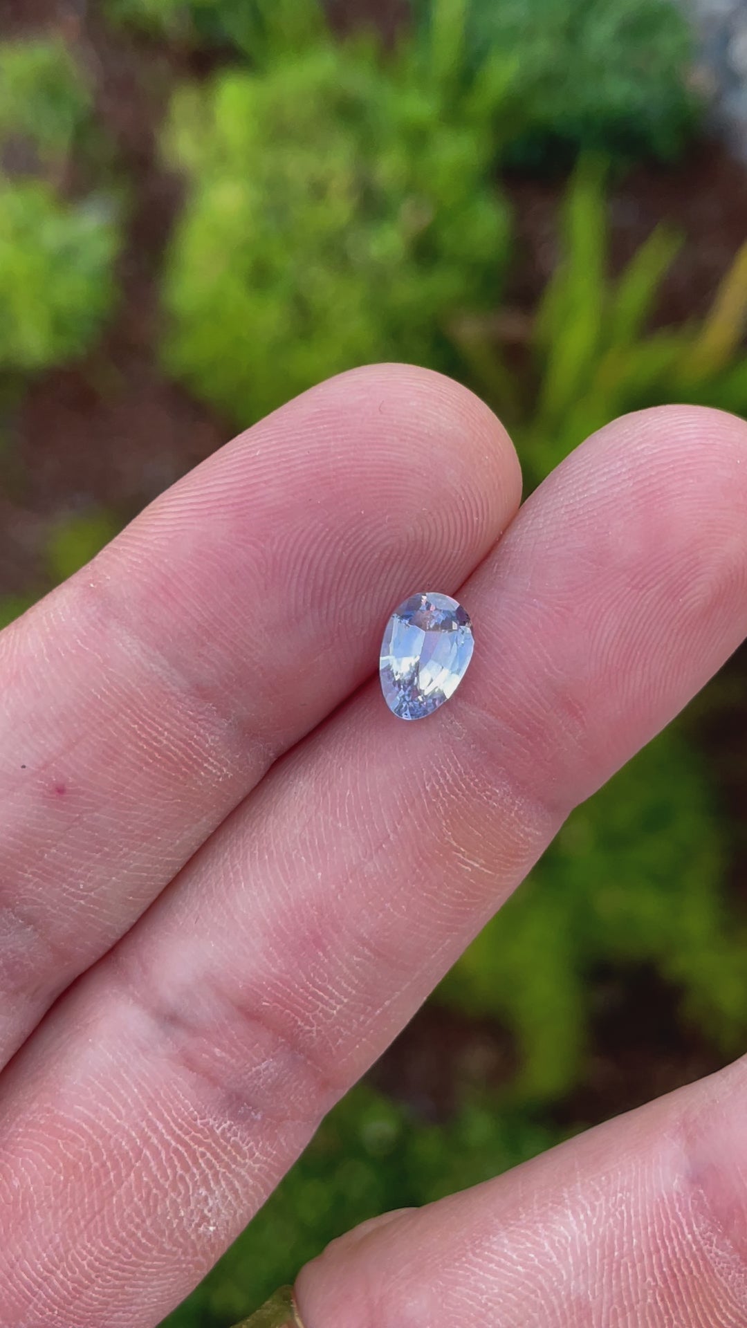 A 1.74-carat Ceylon denim blue sapphire is slowly rotated under natural sunlight to display its custom Poval cut. The video captures the play of light across the facets, emphasizing the stone’s brilliant blue color and clarity. Sourced from Sri Lanka, the untreated gem has dimensions of 9.18mm by 6.38mm by 3.82mm.