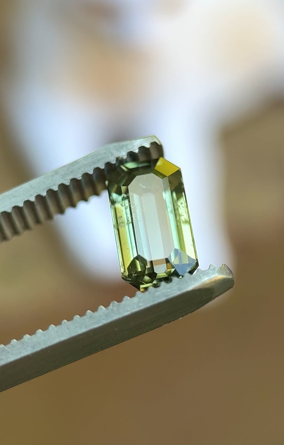 Rotating video of 1.80ct antique emerald cut teal green sapphire in natural outdoor lighting showing color shifts and brilliance