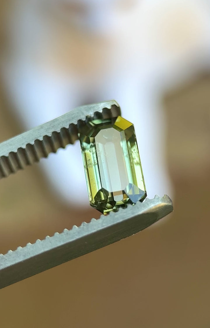 Rotating video of 1.80ct antique emerald cut teal green sapphire in natural outdoor lighting showing color shifts and brilliance