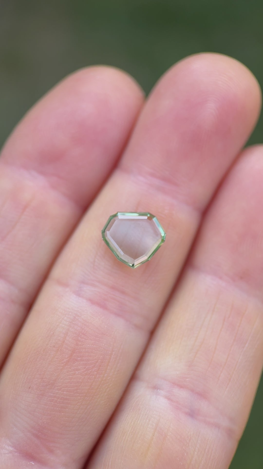 ideo showcasing a 2.58-carat Montana sapphire with bluish seafoam green hue in a custom shield portrait cut, rotating for light reflection