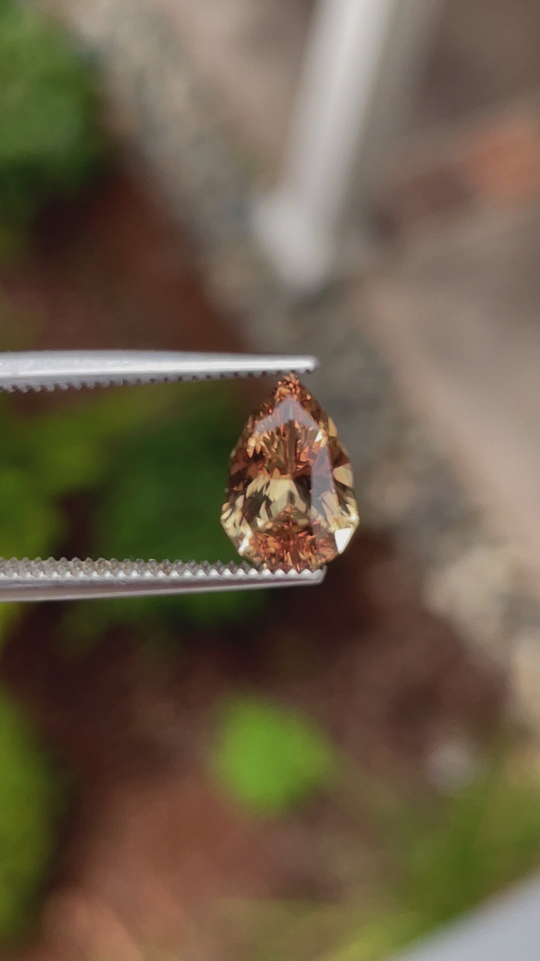 360-degree view of a yellow-brown sapphire, 2.04 carats, held in tweezers to highlight its golden-brown hue and precise facets.