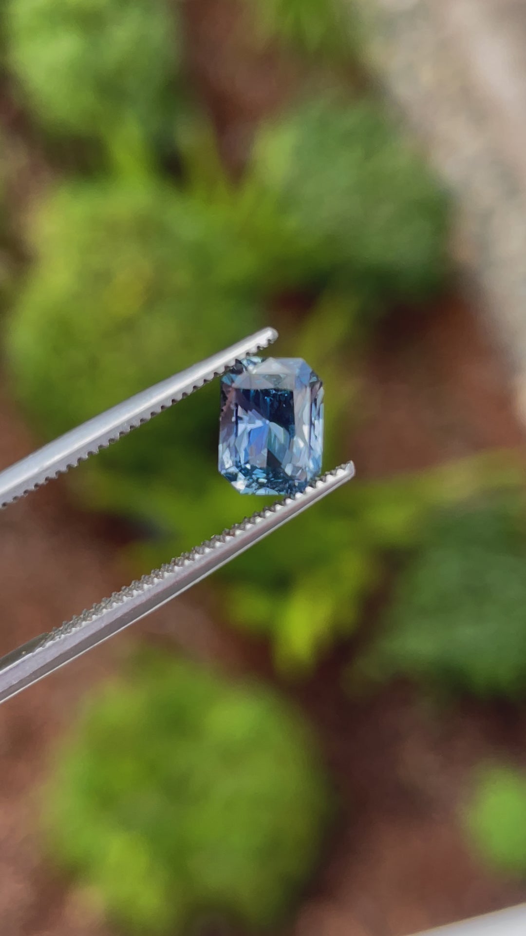 A rotating view of a 1.54 carat radiant-cut sapphire displaying blue, indigo, and violet tones, heated for clarity and brilliance, from Sri Lanka.