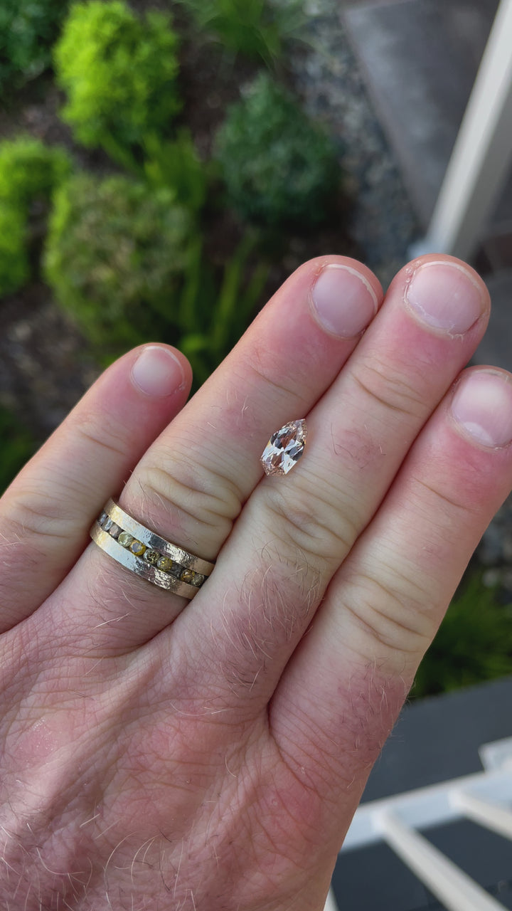A 360-degree view of a 2.07-carat peach and champagne sapphire in a custom geometric shield brilliant cut. The video emphasizes the stone’s unique shape and brilliant reflection of light. This untreated sapphire from Sri Lanka measures 11.02mm by 5.87mm by 3.94mm.