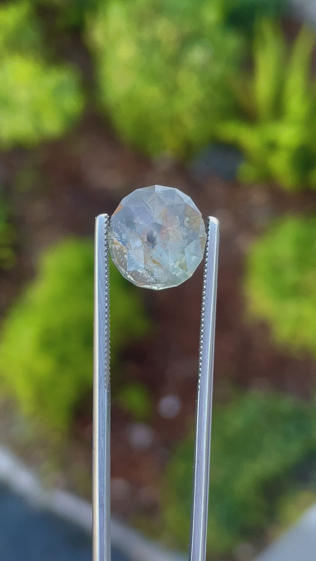 A video showcasing a 360-degree view of an untreated 6.38-carat sapphire with mesmerizing green, gray, and yellow colors. The modified round Portuguese-style cut enhances its brilliance and light play.