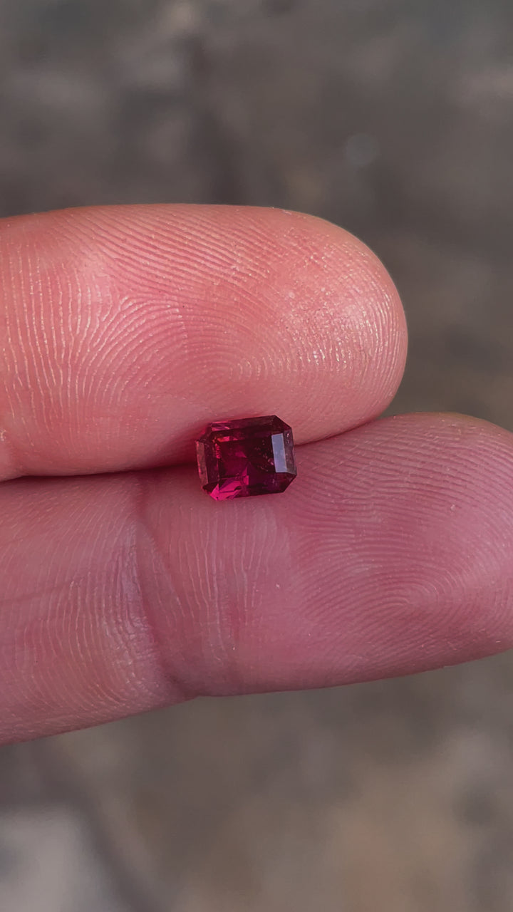 Detailed video of a red-pink garnet gemstone weighing 1.36 carats, sourced from Kenya, showing its modified octagonal step cut and exquisite untreated quality.