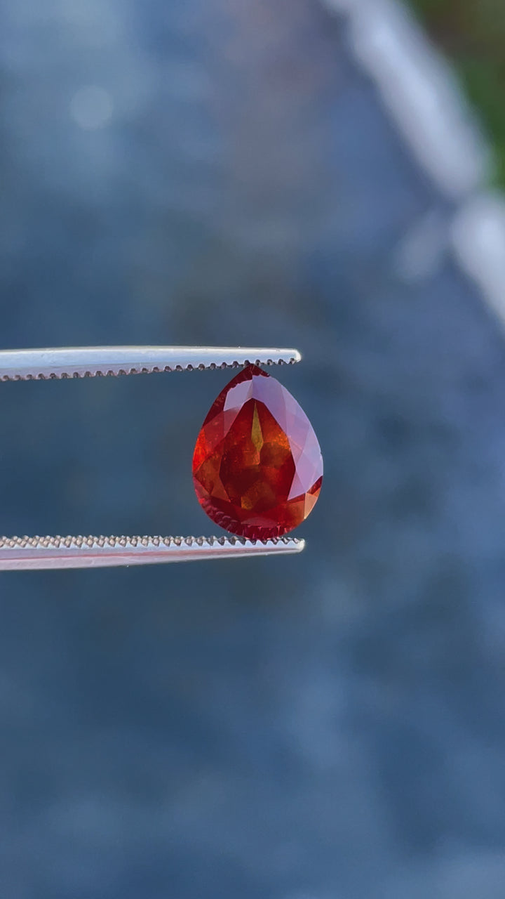 A video of a pear-cut 2.90-carat sapphire with orange and red hues, expertly filmed to showcase its unique brilliance and vibrant tones.