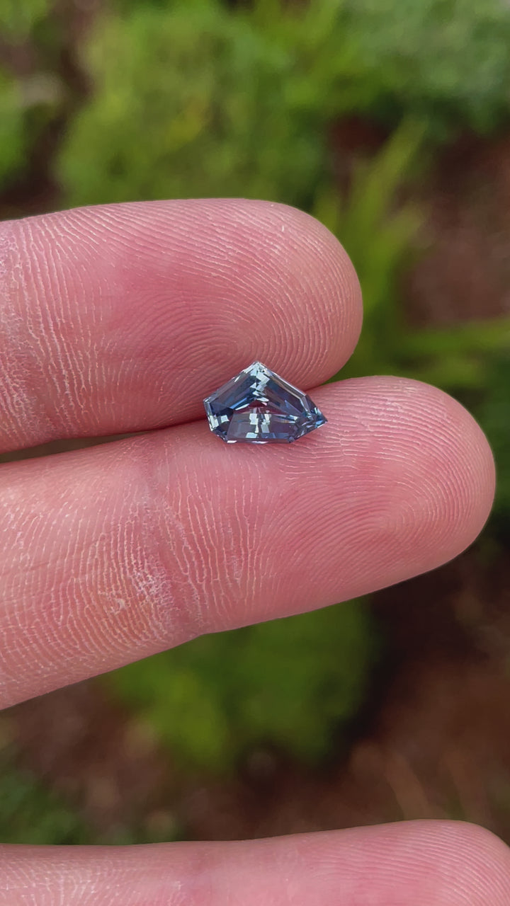 A detailed video showcasing the beauty of a 2.23-carat blue sapphire with a unique free-form geometric cut. The video highlights the stone's clarity, facets, and natural charm. Origin: Sri Lanka, Untreated.