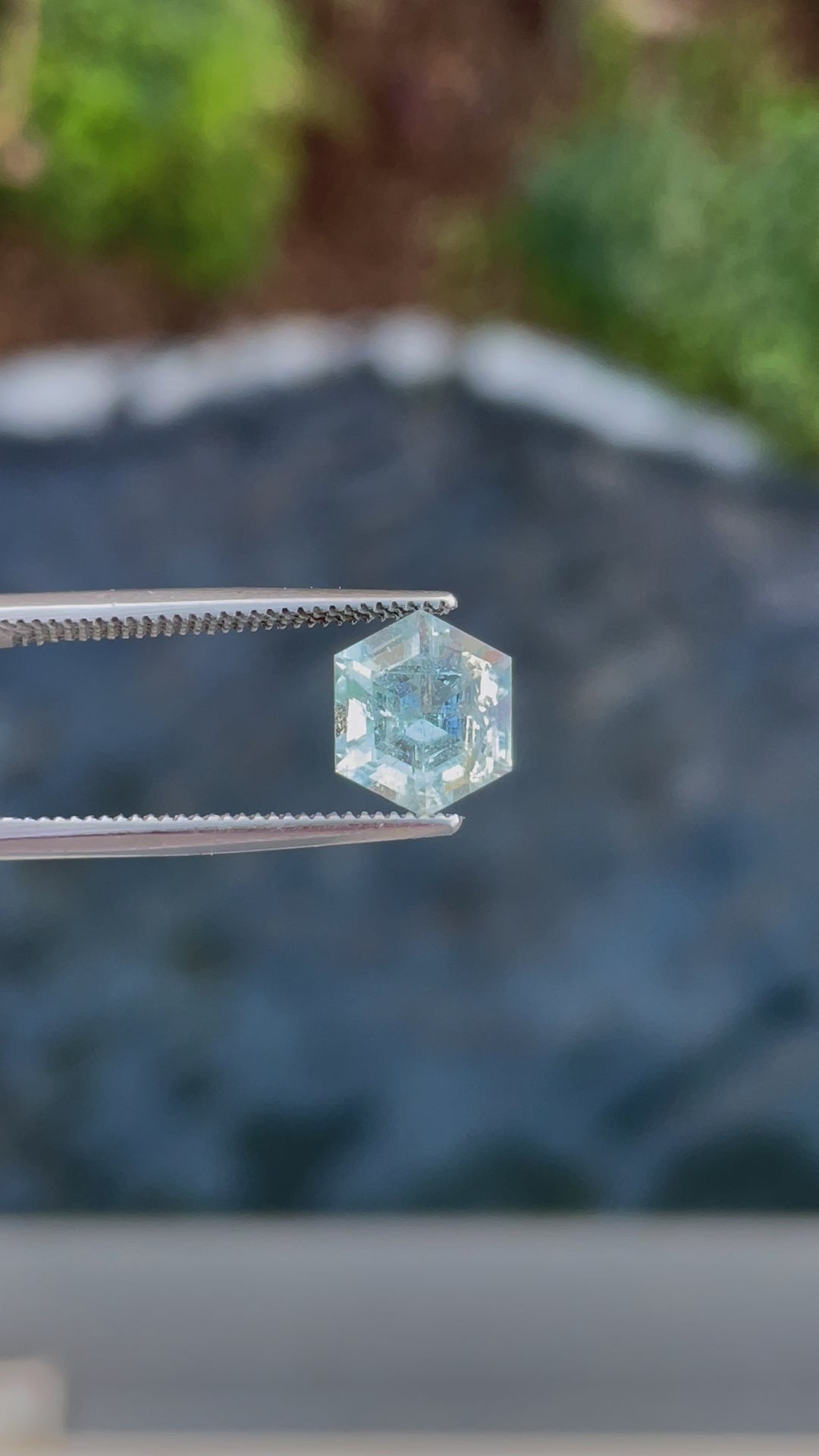 A rotating 2.20ct Green Beryl gemstone in tweezers, capturing its dazzling light reflection and unique hexagon cut.