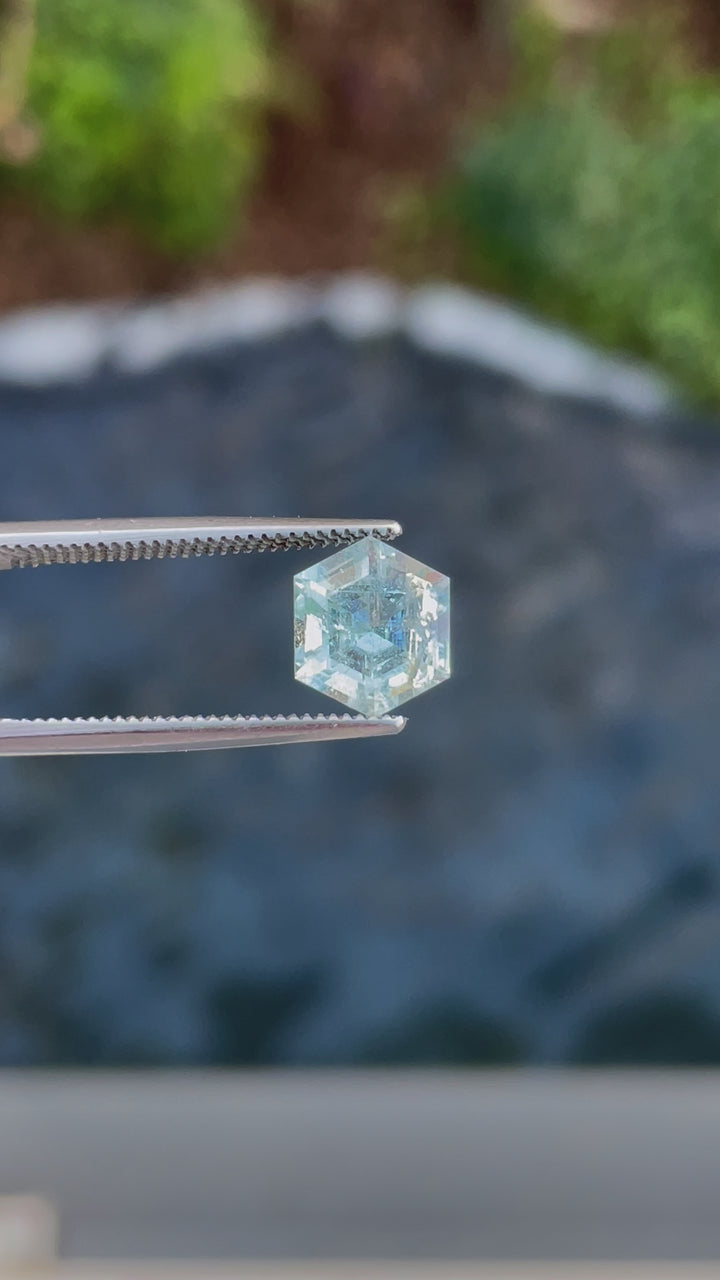 A rotating 2.20ct Green Beryl gemstone in tweezers, capturing its dazzling light reflection and unique hexagon cut.