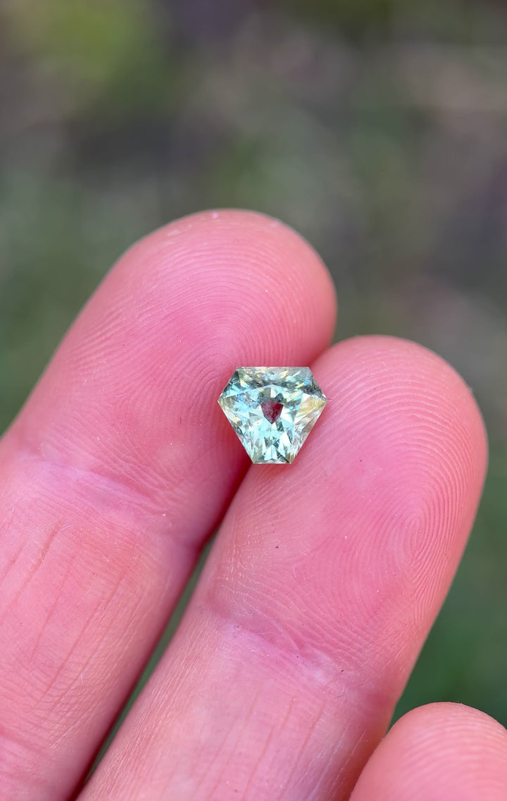 Natural light video of a mint teal green sapphire in custom antique trillion cut, showing sparkle, depth, and color play of an untreated Montana sapphire