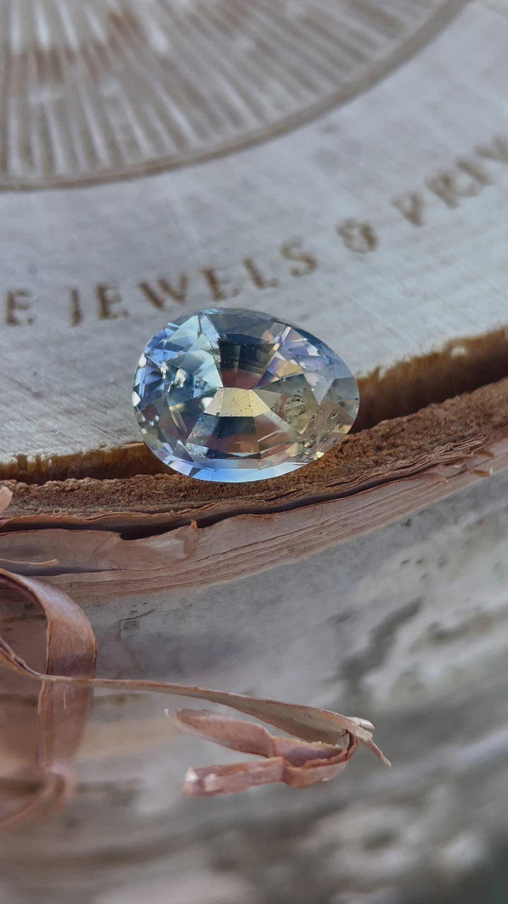 A 1.95-carat Parti Yellow and Blue Sapphire showcasing its unique color blend and brilliance in motion. This unheated pear-oval gem, ethically sourced from Sri Lanka, is displayed with dynamic angles to highlight its clarity and craftsmanship.