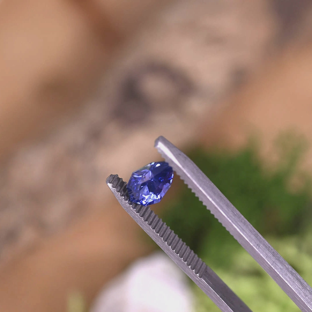Rotating loose blue purple sapphire from Ratnapura Sri Lanka showing the brilliance and color shift of the custom mix pear cut as the stone moves in light.
