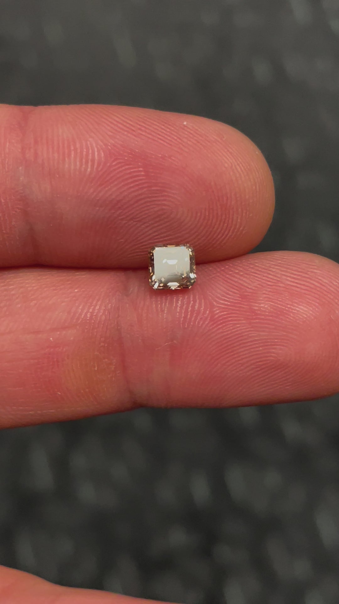 A beautifully lit showcase of a 1.01-carat South African Asscher cut diamond in champagne fancy brown, capturing its unique luster and sparkle from different angles.