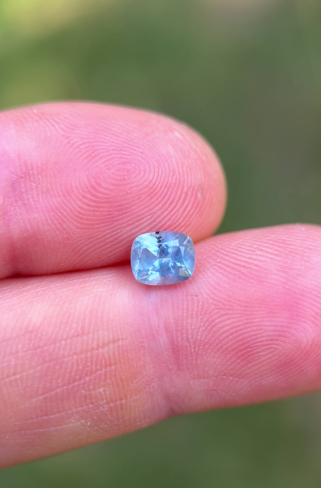 Close-up hand-held video of 1.22 carat custom cut sapphire from Montana, capturing luster and periwinkle tones from various angles