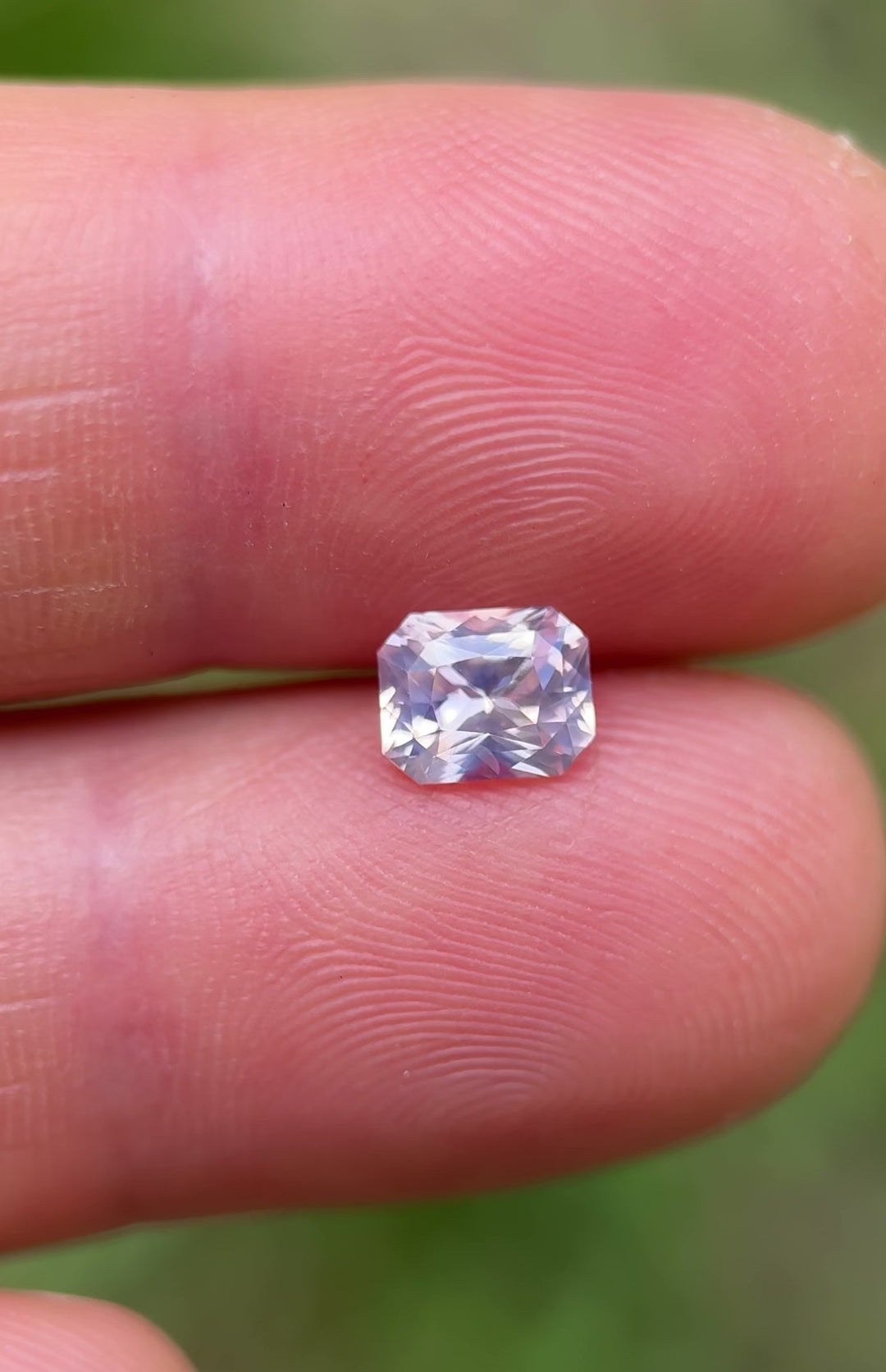 Unfiltered natural light video of a bi-color 1.18CT Sri Lankan sapphire, revealing its soft pastel glow and multi-hued brilliance – ethically sourced and untreated