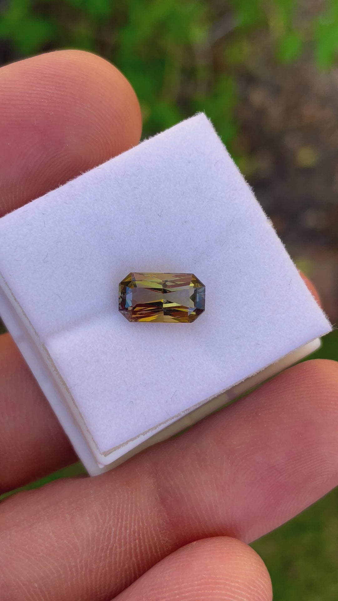Video of a Custom Elongated Radiant Cut Tanzanite Gemstone Showcasing Greenish Golden, Peach, and Yellow Colors, Weighing 2.30 Carats, with Dimensions 10.59 x 6.05 x 4.43 mm, from Merelani Hills, Arusha Region, Tanzania - No Treatment
