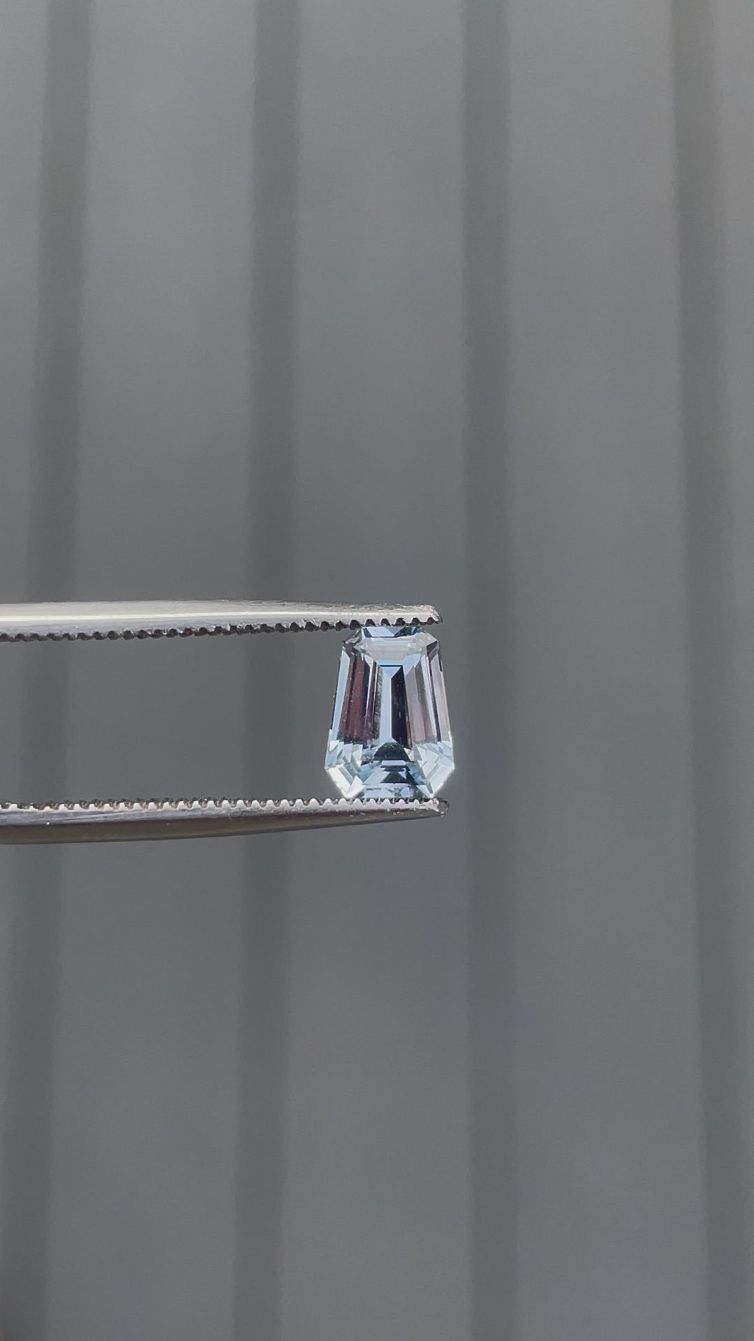 Video of a 1.64 carat pale blue sapphire in a fancy mixed cut, gently rotated to display its clear blue color and sparkling facets. Captured under natural light to enhance its unique shine and pristine clarity.