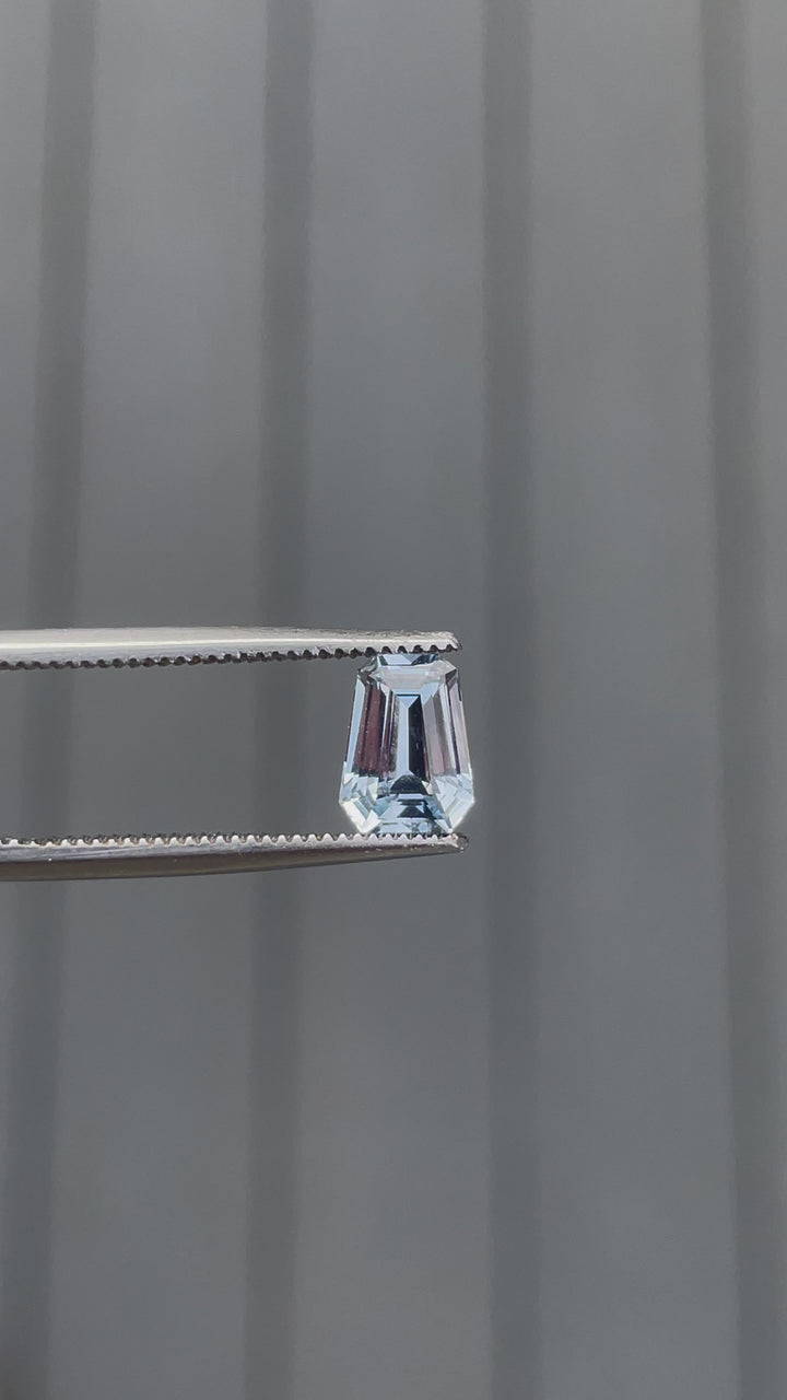 Video of a 1.64 carat pale blue sapphire in a fancy mixed cut, gently rotated to display its clear blue color and sparkling facets. Captured under natural light to enhance its unique shine and pristine clarity.