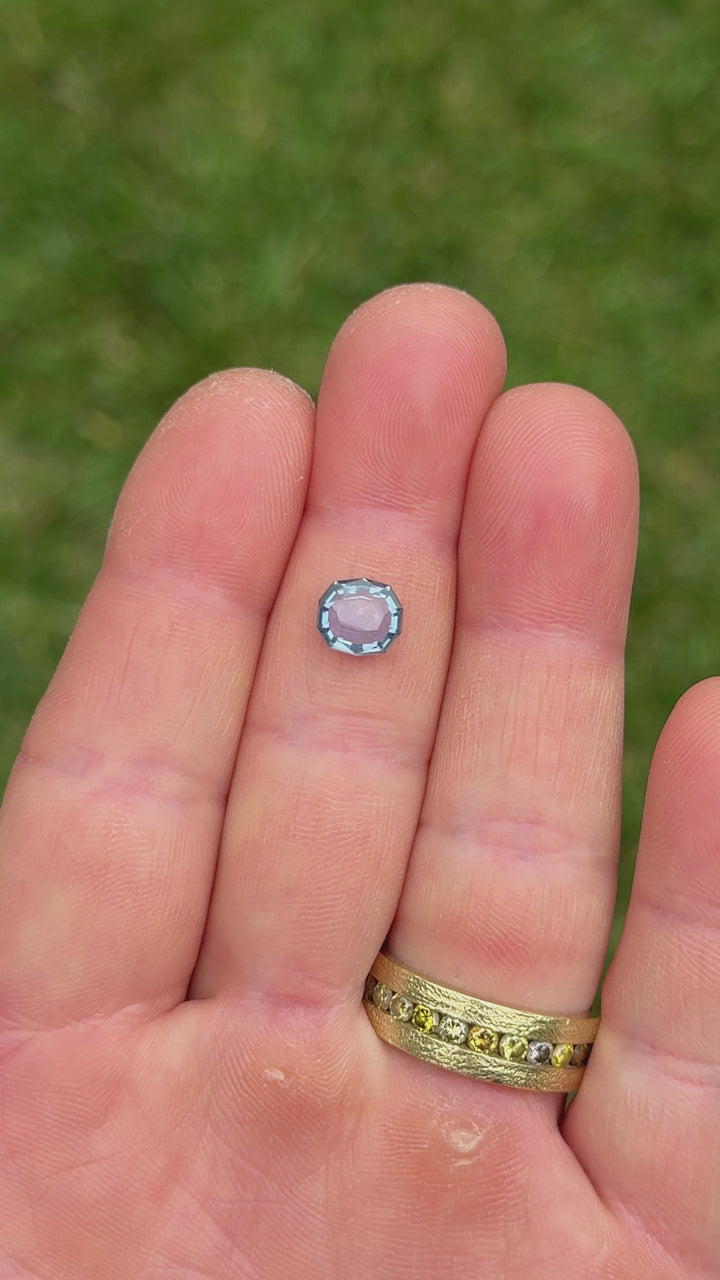 Close-up video of 2.08ct Montana sapphire in hand, capturing the natural color transition from violet to blue in daylight.