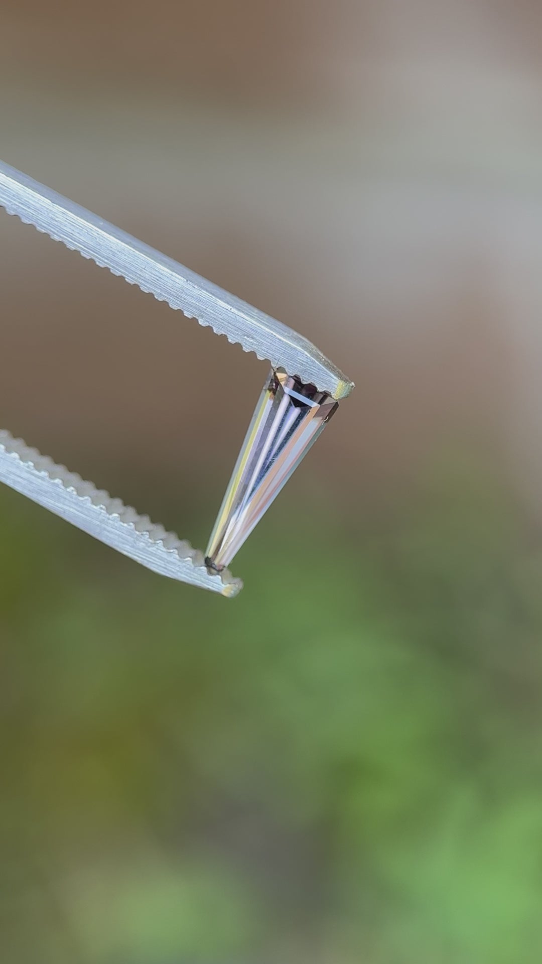 360-degree video of a 0.67-carat Tanzanite in a custom elongated tapered baguette cut, reflecting multi-color hues from Merelani Hills.