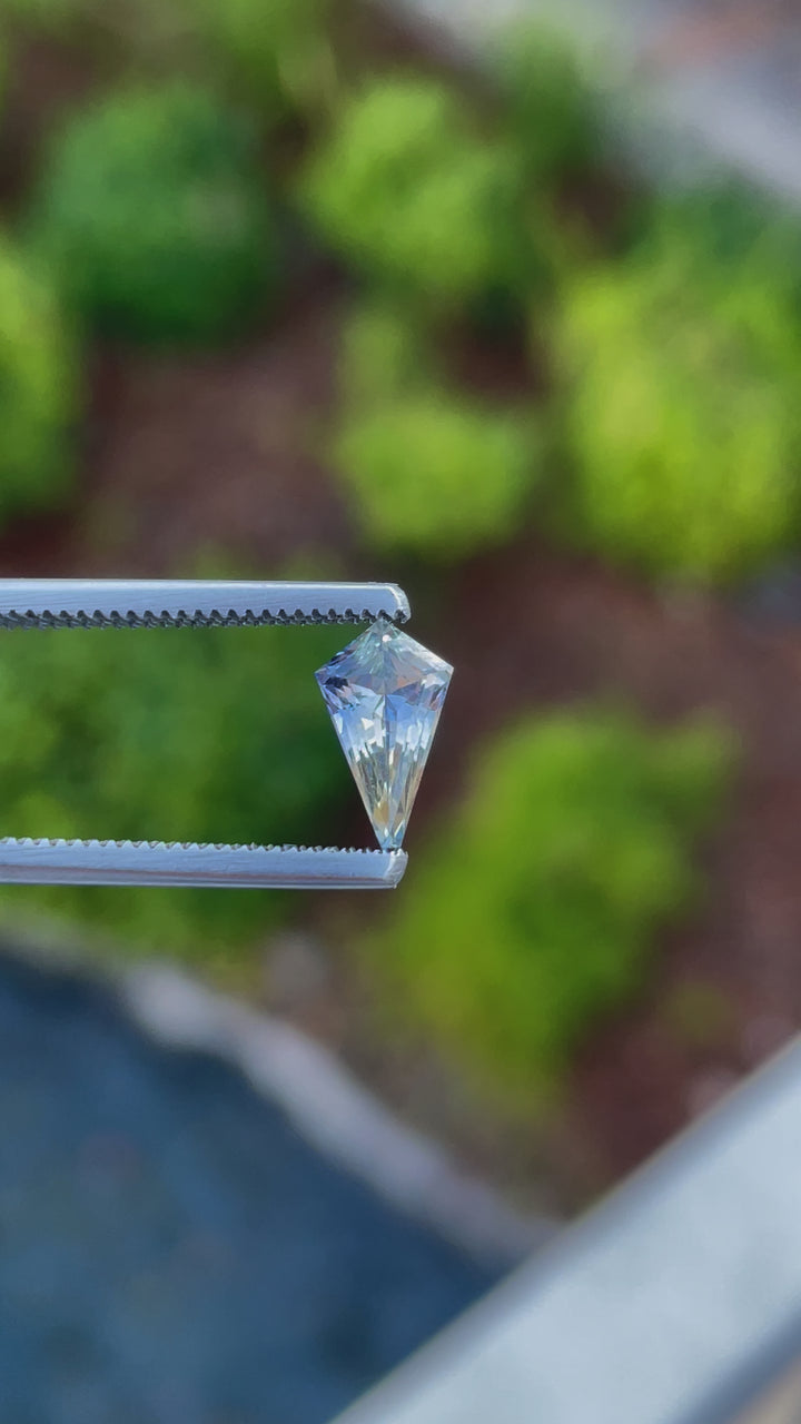 Dynamic display of a 1.20 carat yellow and cornflower parti sapphire, custom mix kite cut, as it captures the light, showcasing its dazzling colors and flawless cut, sourced from Sri Lanka.