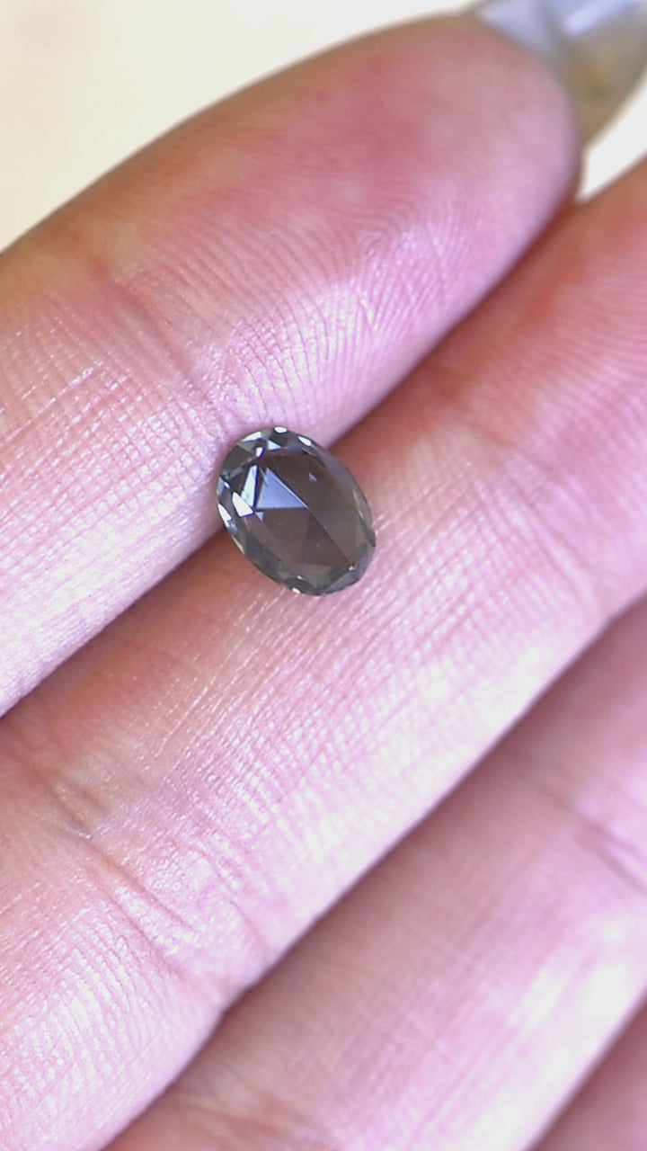 Close-up video highlighting the color shift and geometric brilliance of an oval rose cut sapphire with natural blue-green saturation