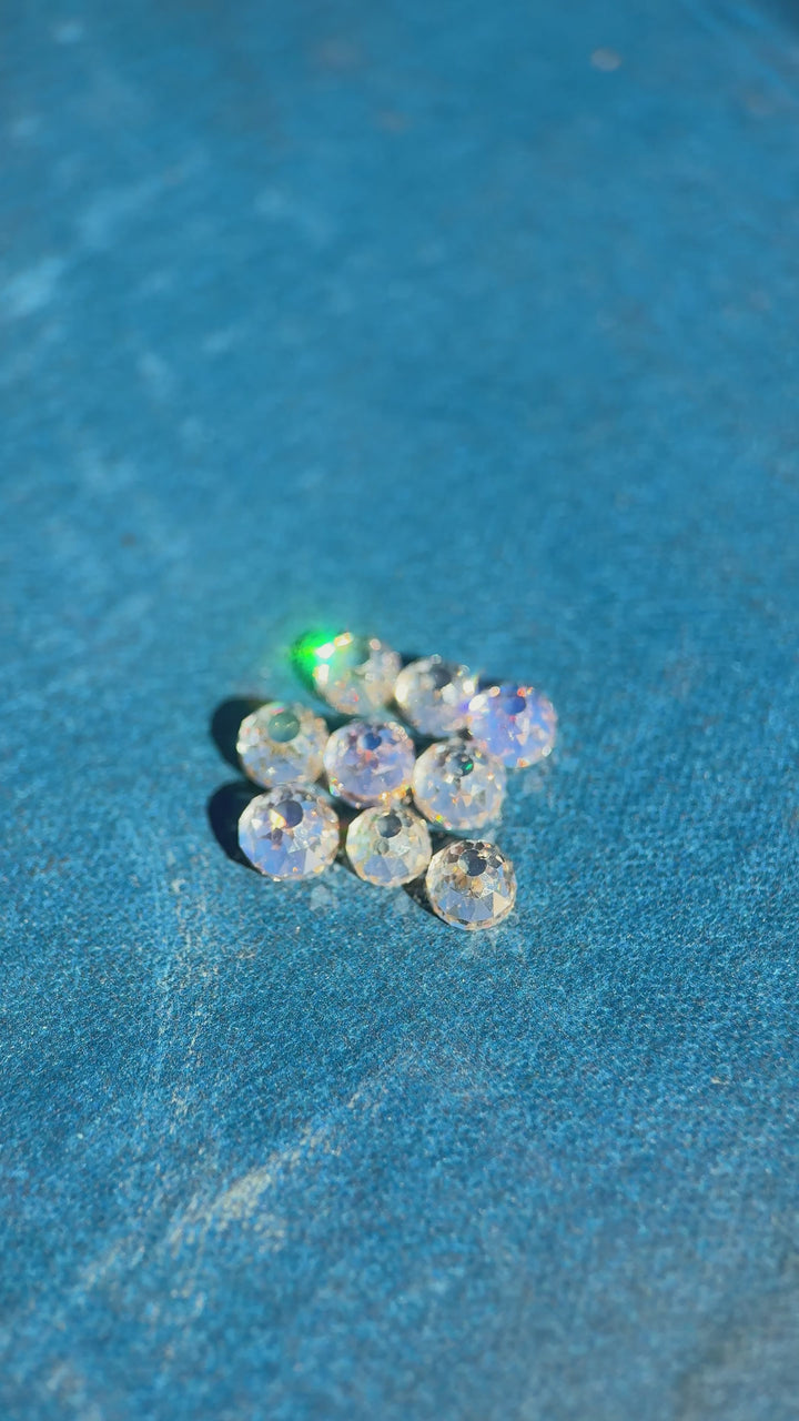 Video of nine Mughal cut diamonds rotating under light to show antique faceting, fancy light brown color, VVS clarity, and light blue fluorescence in a 5.11 carat South African diamond parcel