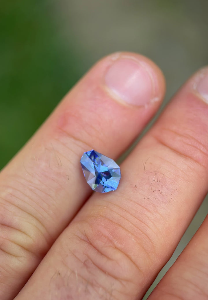 360° rotating video of a 2.26ct custom shield cut Tanzanite showing dynamic shifts in blue and violet under natural light.