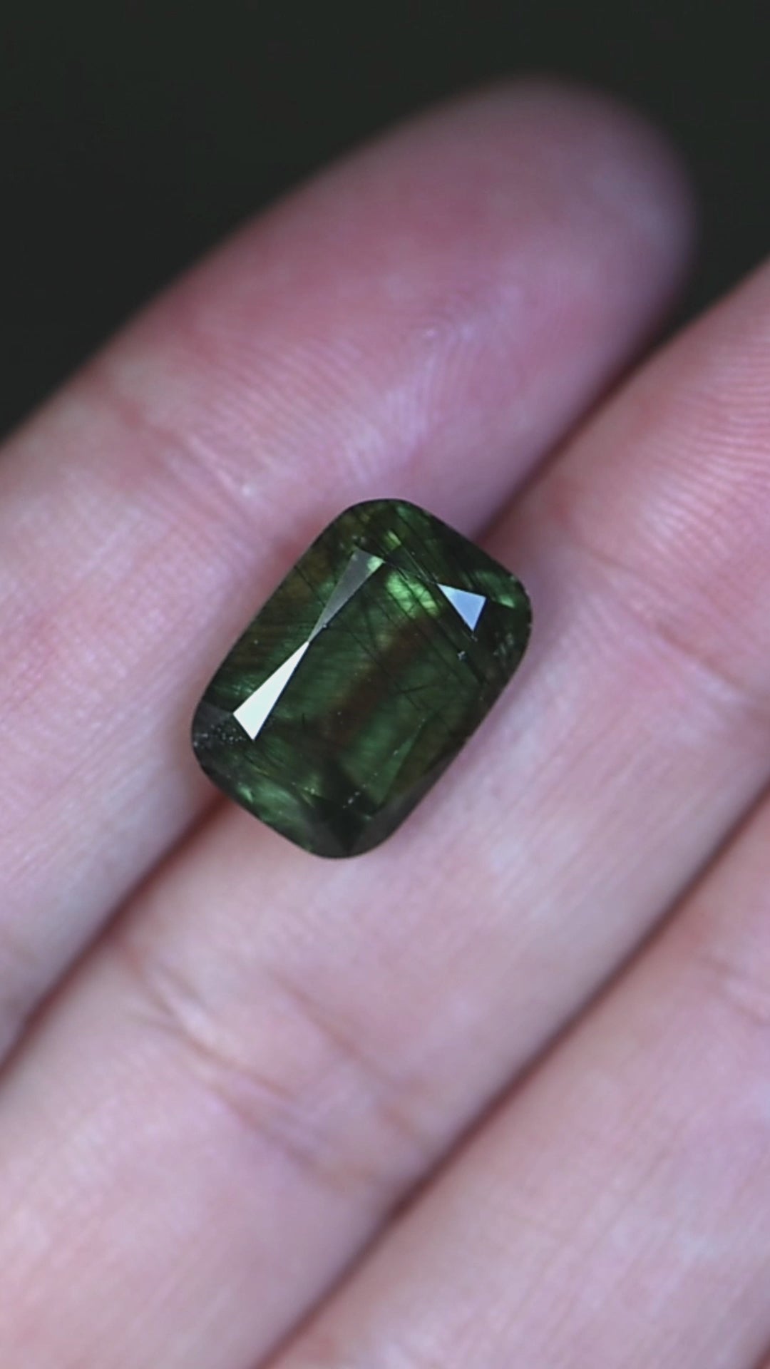 See this natural untreated 8.25 carat peridot from Skardu, Pakistan in hand as its rich forest green color, elongated cushion mix cut, and distinctive crystal inclusions come to life.