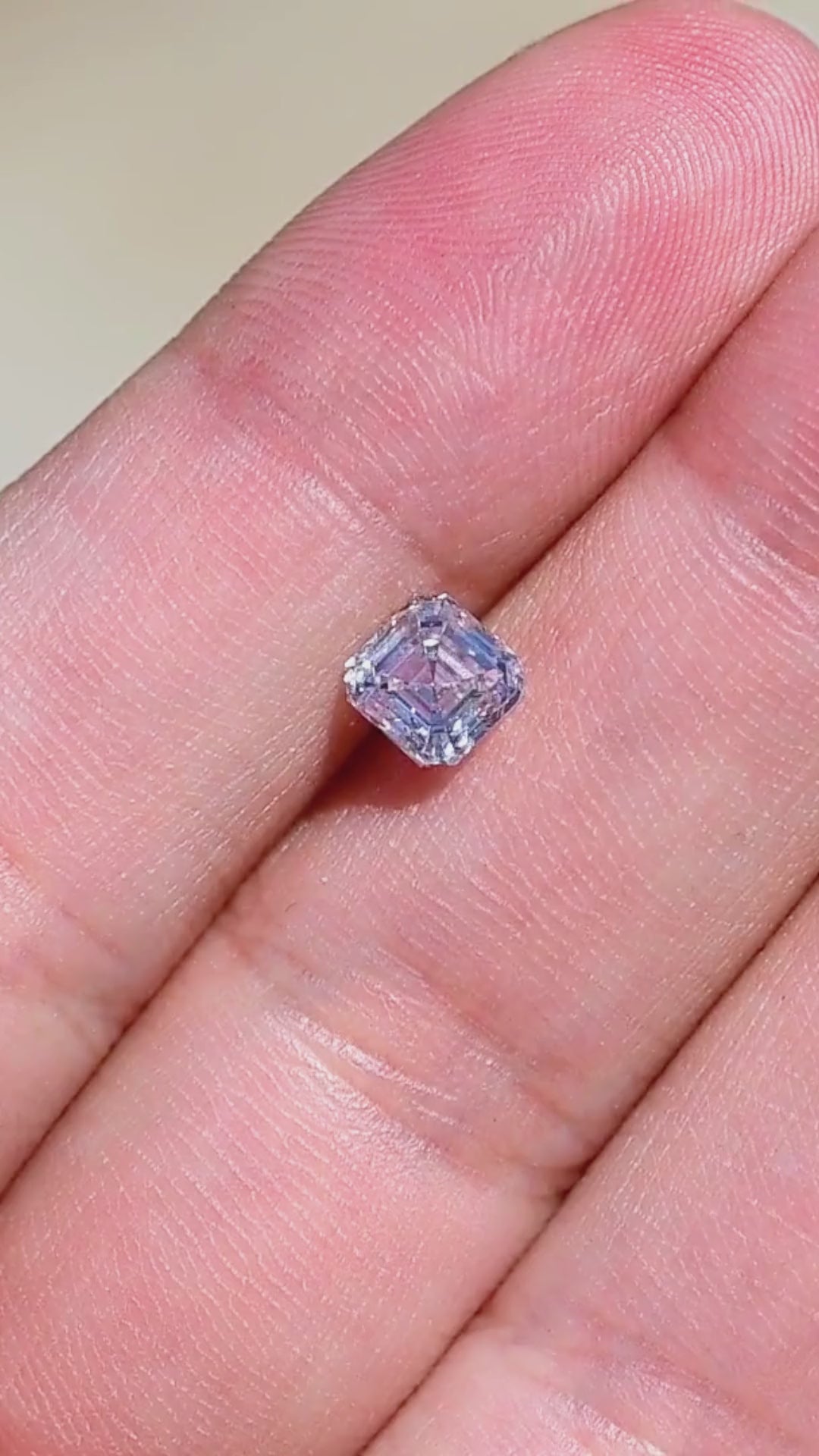 1.03 carat natural Canadian Asscher cut diamond shown on a hand, demonstrating its face-up size, subtle M color warmth and changing geometric reflections.