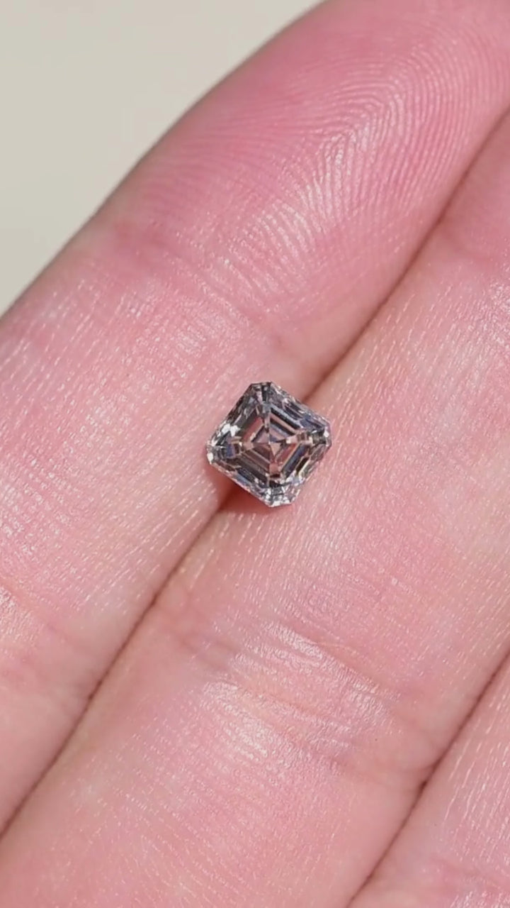 1.02 carat natural Canadian Asscher cut diamond shown on a hand, demonstrating its face-up size, subtle M color warmth and shifting step-facet reflections.