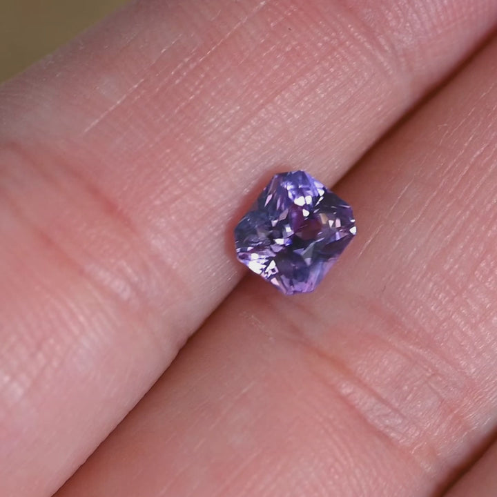 Rotating loose purple and pink sapphire from Sakaraha, Madagascar showing the brilliance and facet structure of the precision radiant cut in natural light.