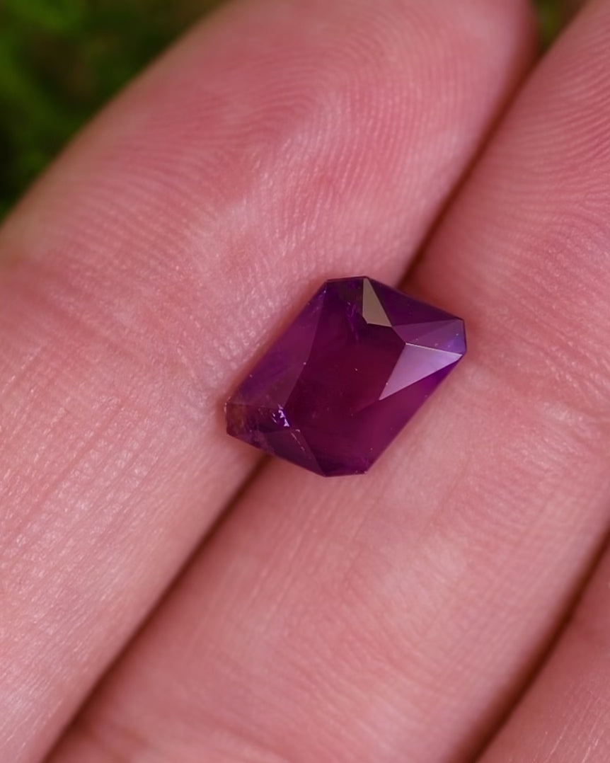Macro video of 2.85 carat radiant emerald cut sapphire displaying vivid pink and red flashes with purple undertones, untreated gemstone from Umba River Valley, Tanga, Tanzania.