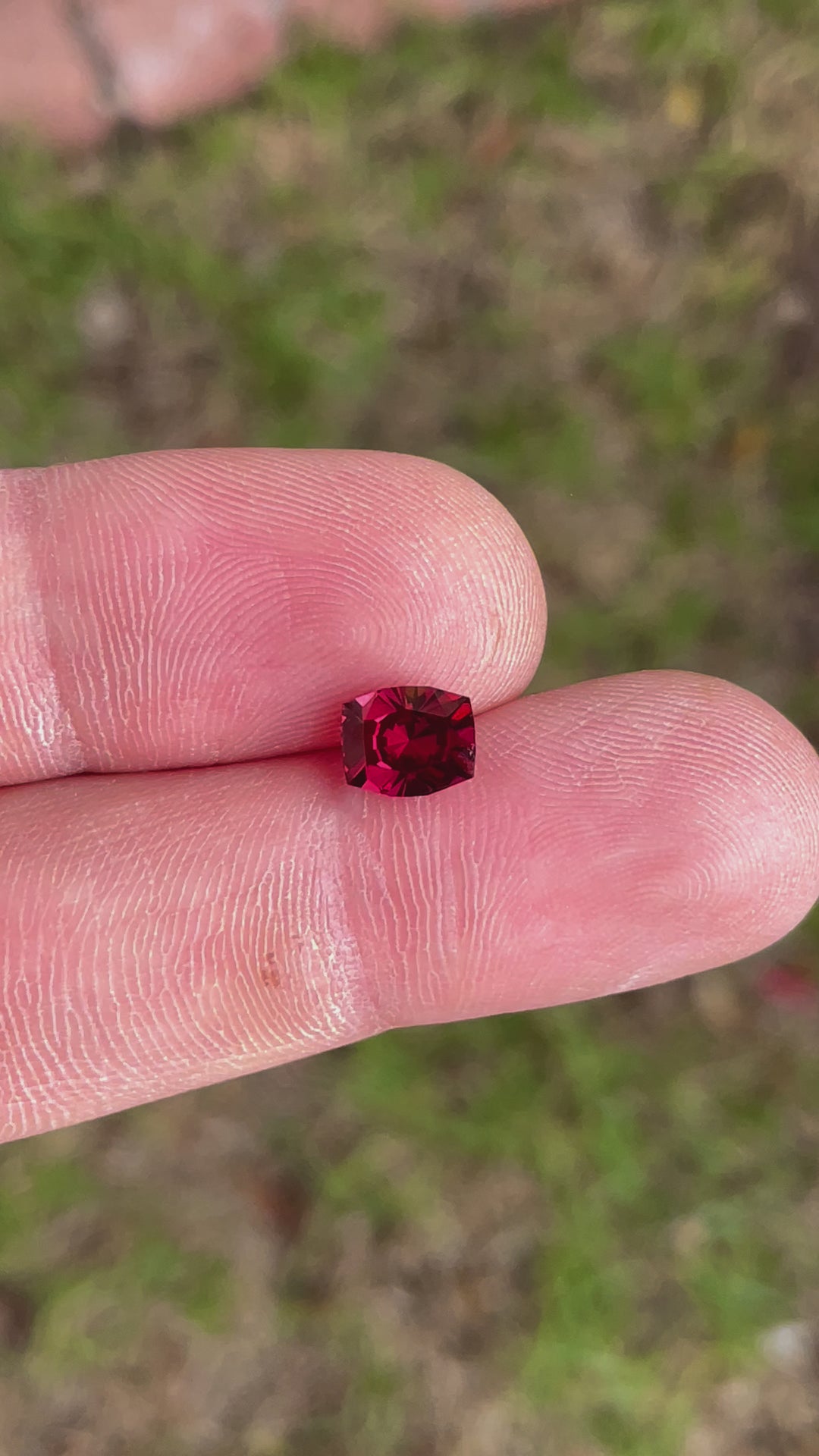 Rotating view of a 1.97 carat natural garnet gemstone in vivid red-purple tones, cushion brilliant cut, sourced from Tanzania.