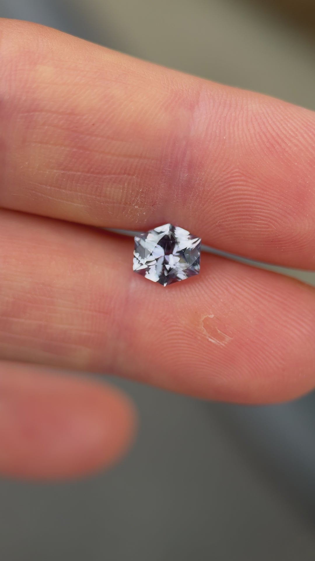 Hexagonal sapphire showing modified brilliant cut and soft shift in tone under indoor lighting