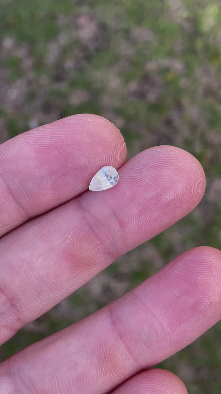 Rotating view of a 1.05-carat pale yellow sapphire in natural lighting, showcasing its shield-cut facets and clarity.
