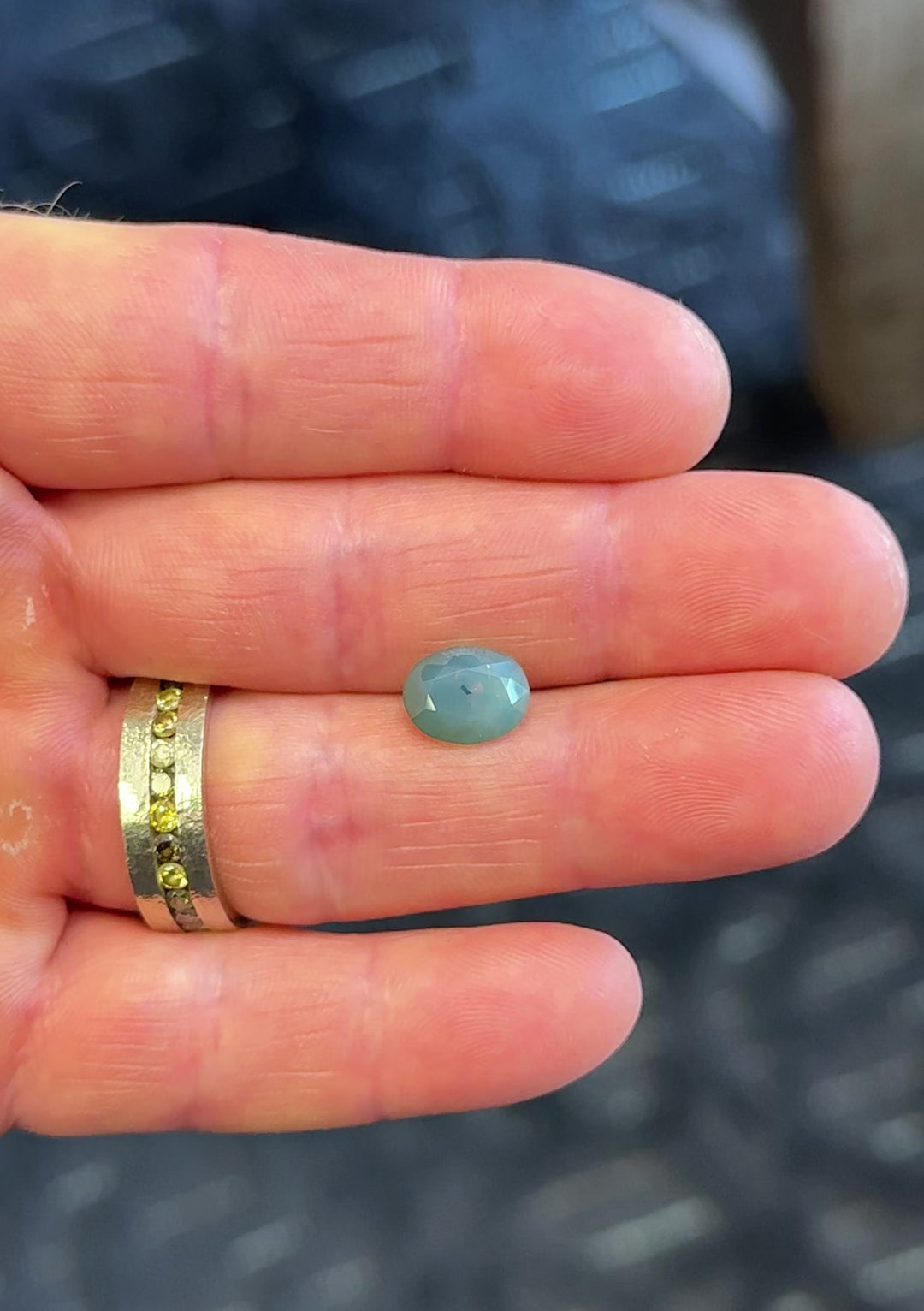 360-degree video of a 4.19CT untreated Gombe sapphire held in hand, showing off its teal blue hues and glowing opalescent effect.
