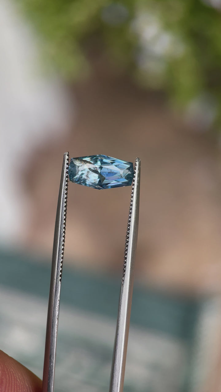 A rotating 2.14-carat denim blue sapphire with a custom geometric elongated cushion cut. The video captures the sapphire’s rich blue hues and detailed facets as it rotates under natural light. The untreated gemstone is from the Umba River, Tanzania, and measures 10.66mm by 5.55mm by 4.17mm.
