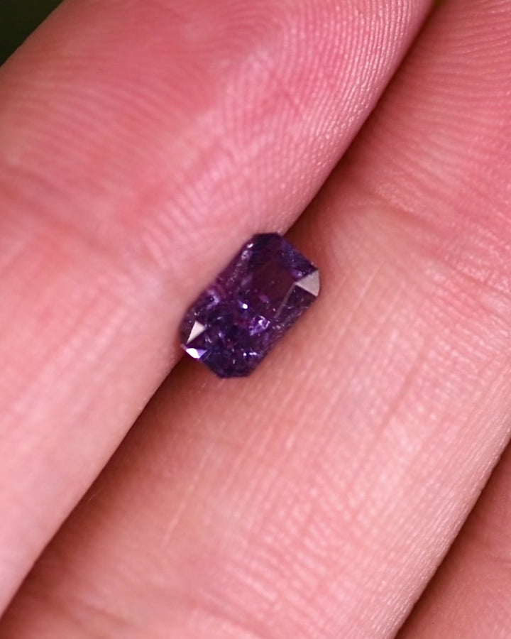 Close-up video showcasing the brilliance of a 0.94 carat gray purple sapphire, turning gently to highlight its custom radiant cut and natural untreated color, sourced from Umba River Valley, Tanzania.