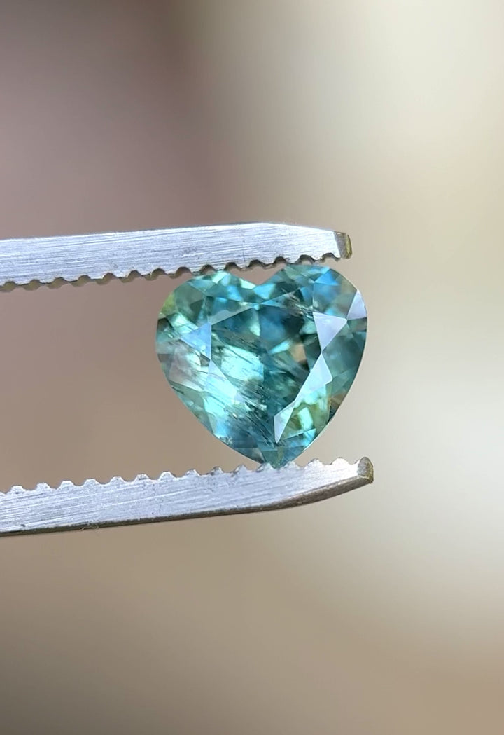 Rotating video of 1.71ct Montana heart sapphire showing teal, blue, and green tones in daylight.