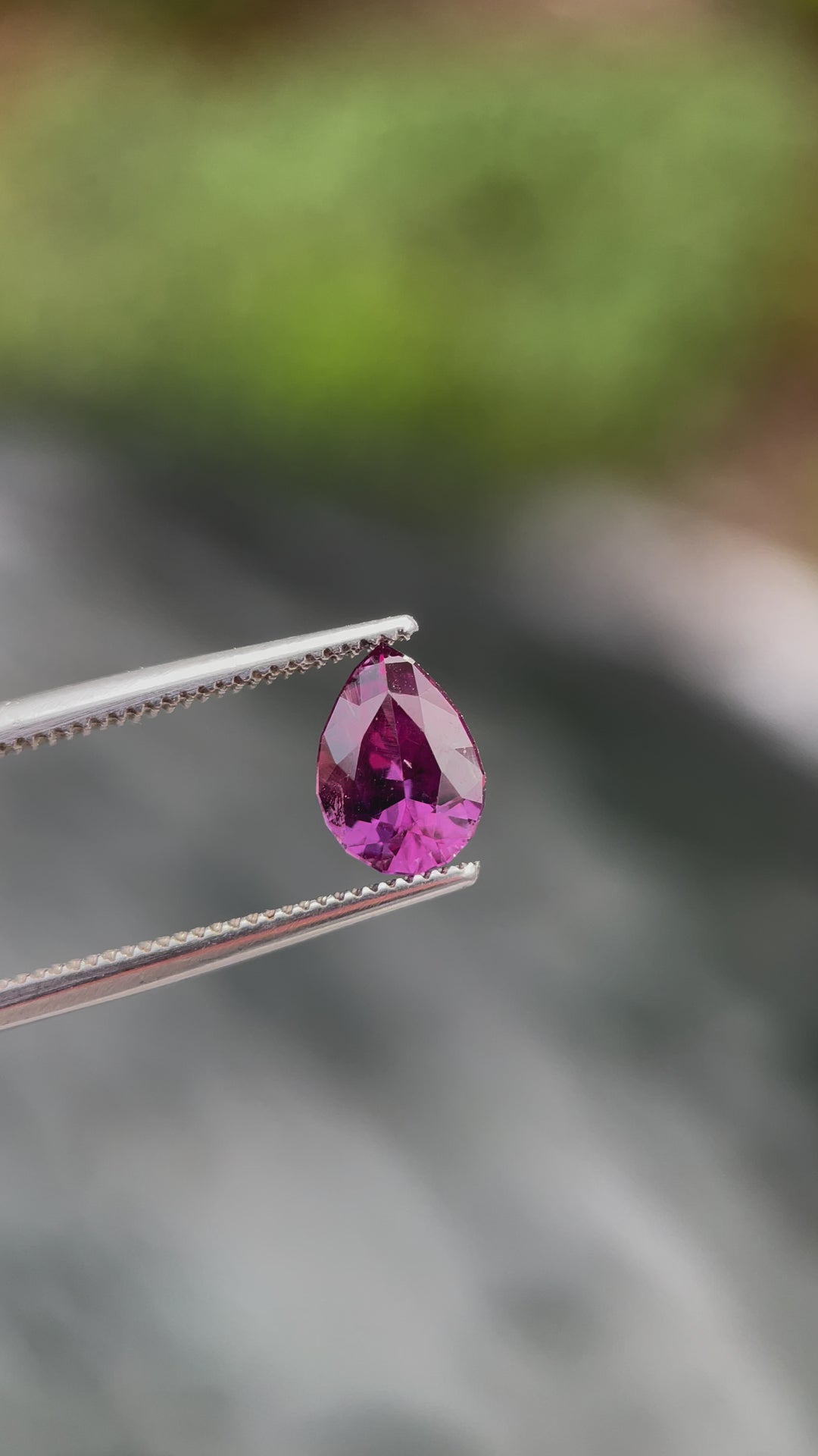 A video showing a 1.45-carat pinkish-purple pear-shaped sapphire rotating under light, highlighting its brilliance and cut.