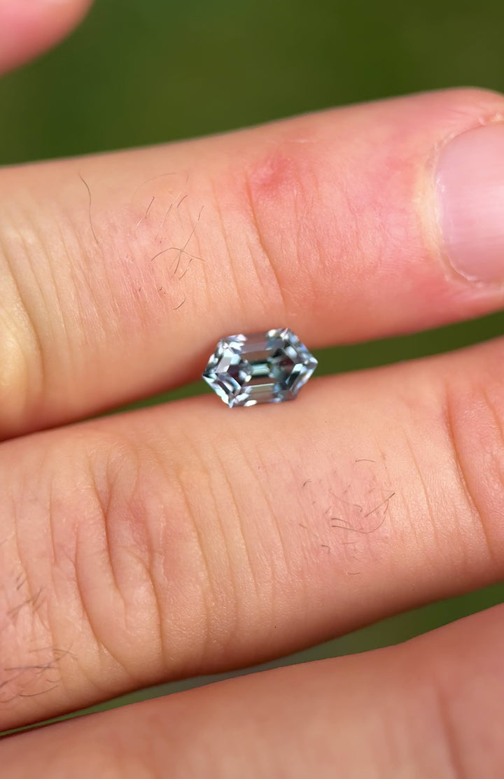 Rotating video of untreated Tanzanite in natural light showcasing teal, green, and purple color flashes in elongated step hexagon cut