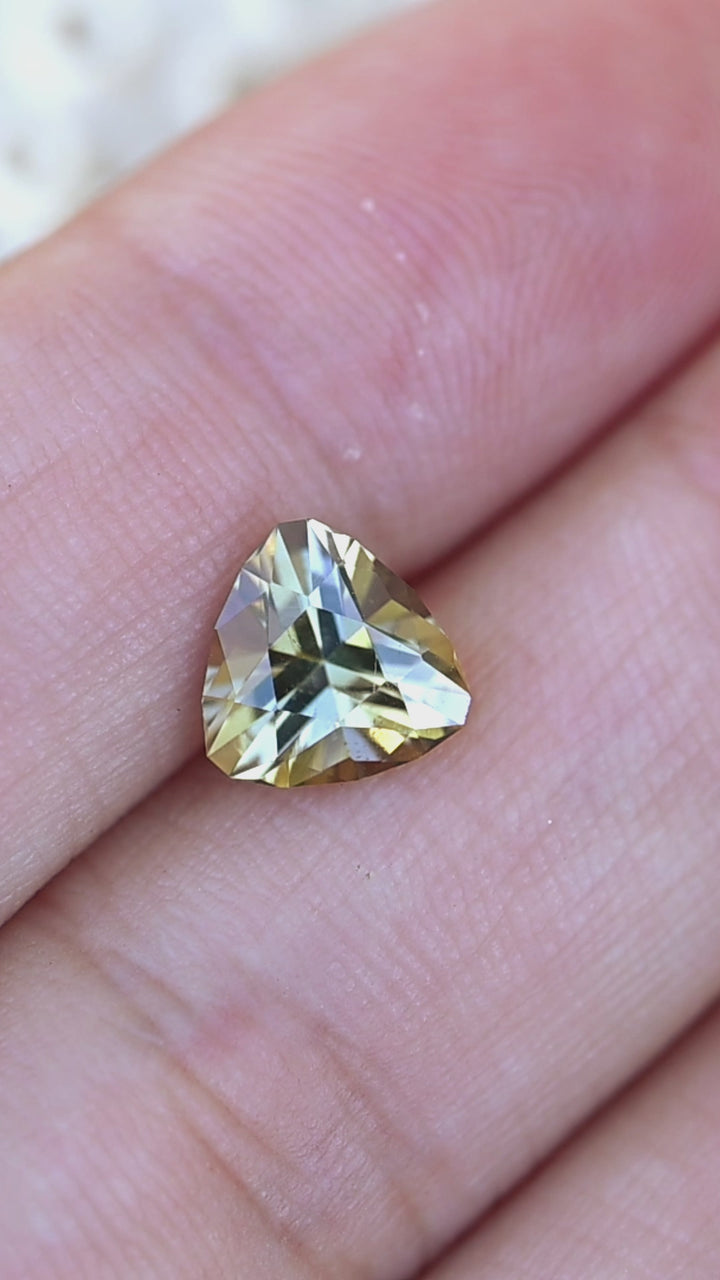 Experience the rare natural pleochroism of this untreated Merelani tanzanite as its custom brilliant trillion cut reveals vibrant flashes of teal, green and warm golden yellow.